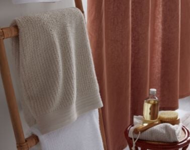 Towel hanging with bath brush and bath oils Towel hanging with bath brush and bath oils